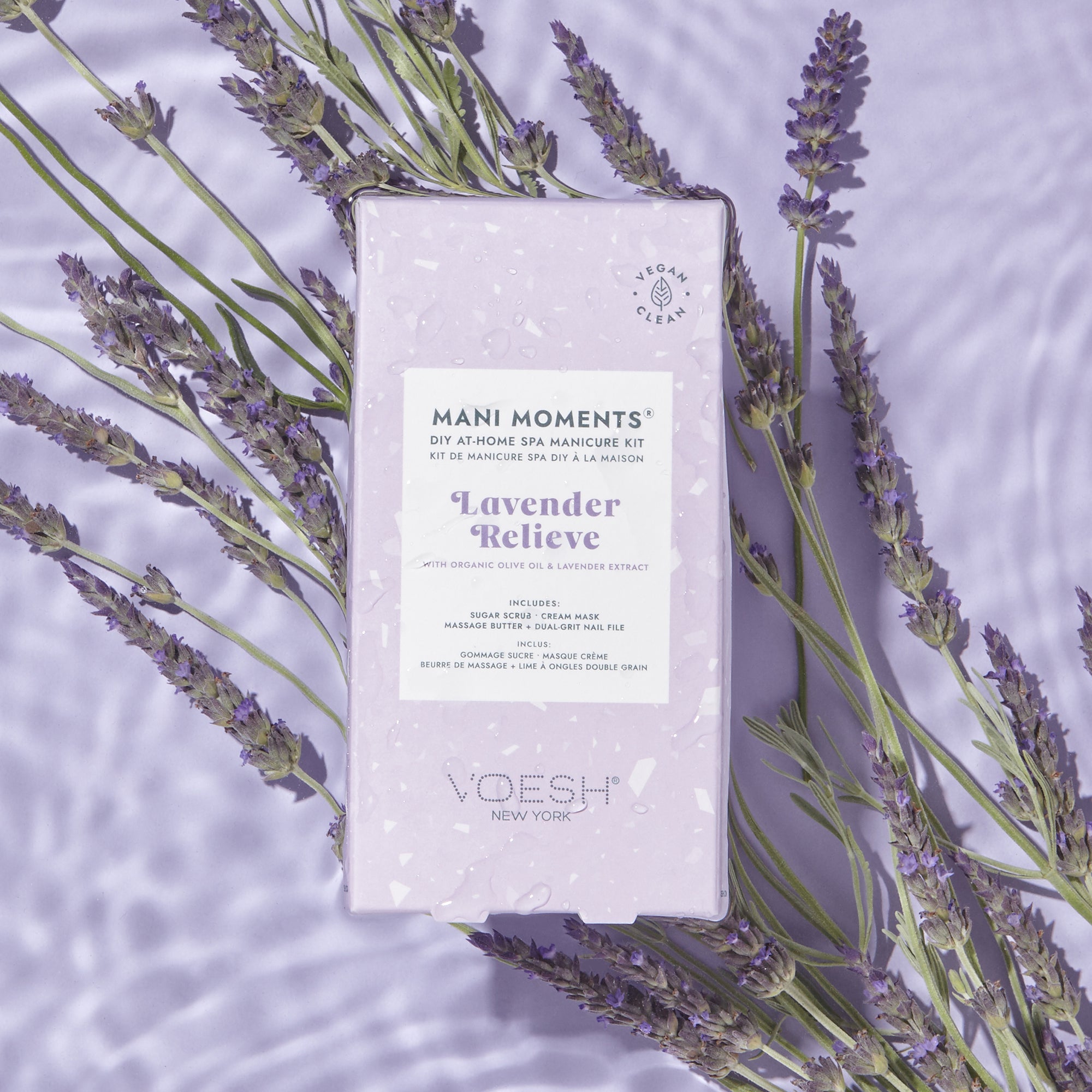 VOESH Mani Moments Lavender Relieve manicure kit surrounded by lavender flowers on a light purple background